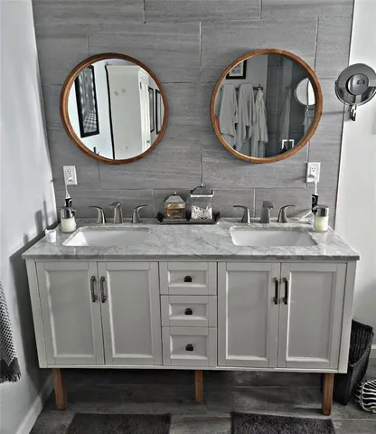 a bathroom with double vanity and a mirror