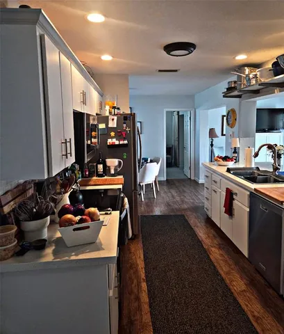 a room with lots of white furniture and chandelier