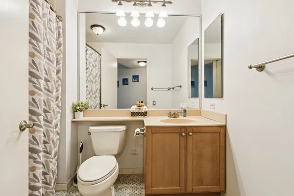 a bathroom with a toilet sink and mirror