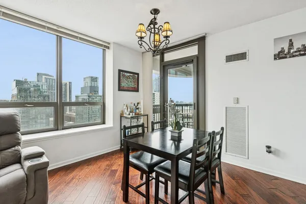a dining room with furniture a chandelier and wooden floor