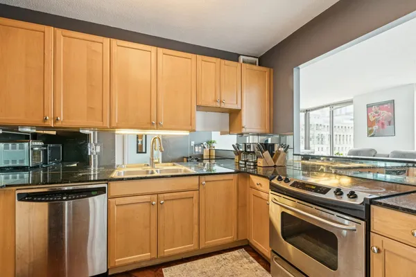 a kitchen with stainless steel appliances a sink stove and cabinets