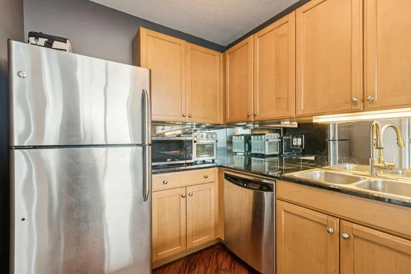 a kitchen with stainless steel appliances granite countertop a refrigerator and a sink