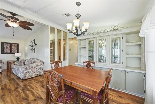 a view of a dining room with furniture a chandelier and wooden floor
