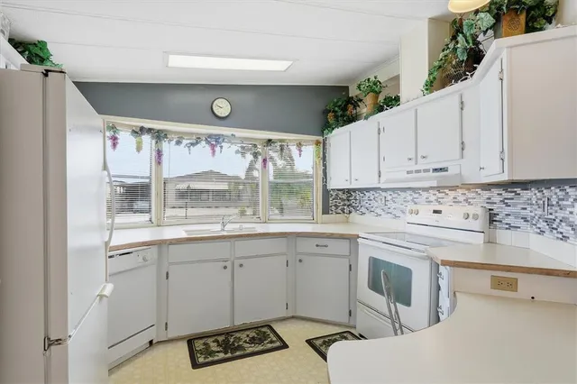 a view of a kitchen with a sink a window and cabinets