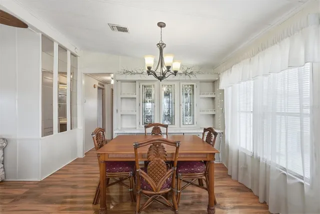 a bedroom with a bed a chandelier and a dresser
