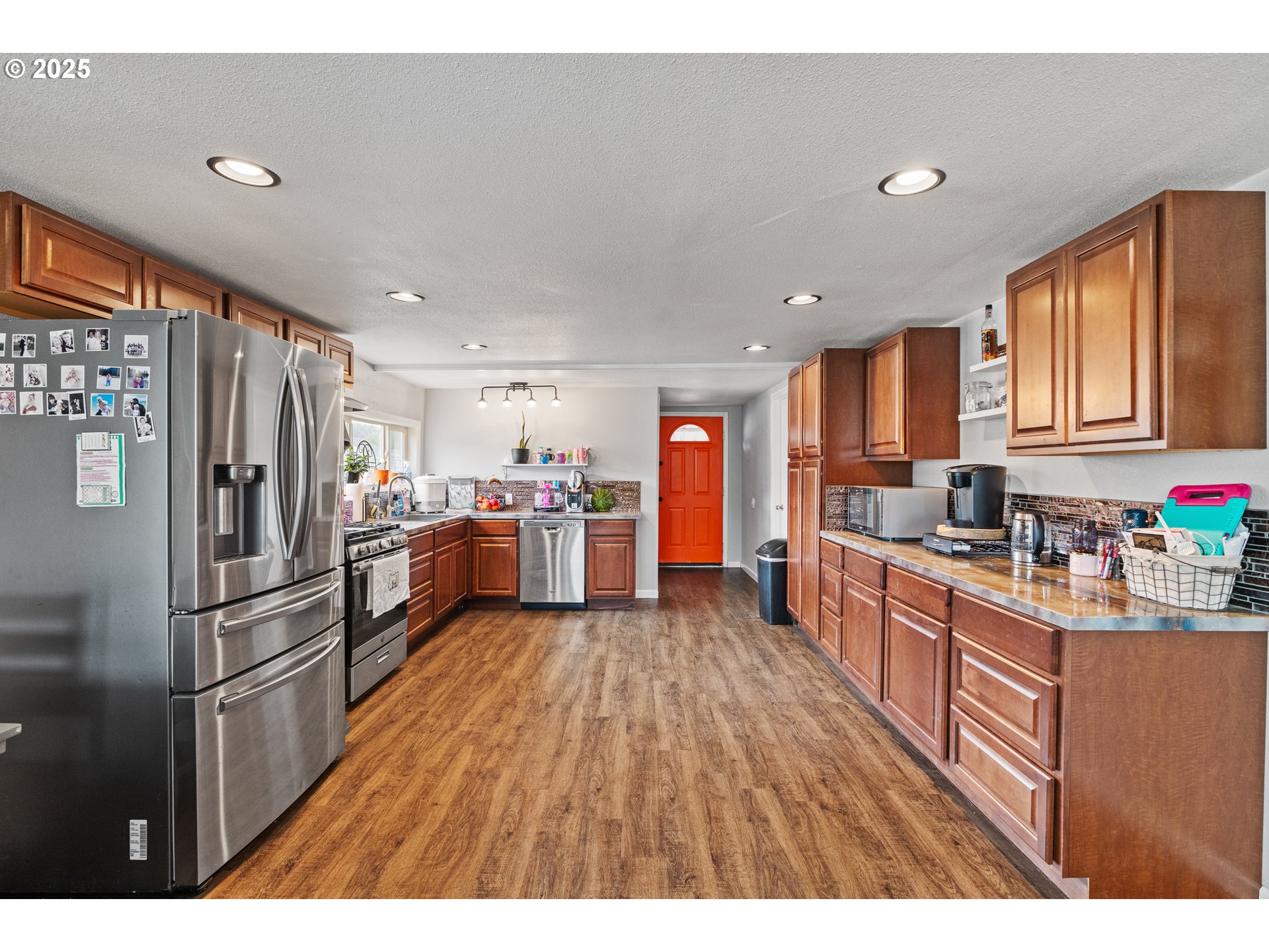 1434 Maryland Avenue Myrtle Point, OR 97458 - Photo 8 of 24 a kitchen with stainless steel appliances granite countertop a refrigerator a sink dishwasher a stove and white countertops with wooden floor