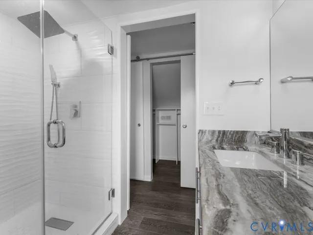 an empty room with wooden floor ceiling fan and windows