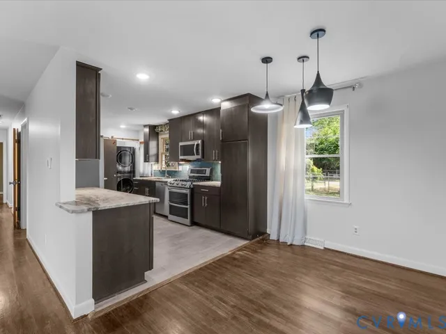 a kitchen with refrigerator and chairs