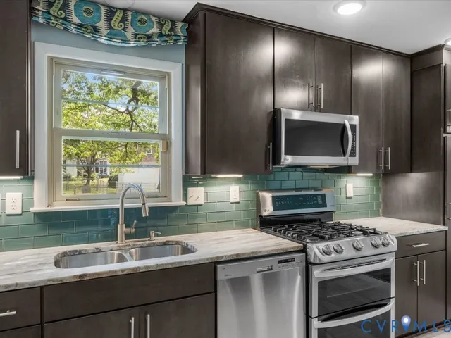 a kitchen with a sink a stove and a microwave