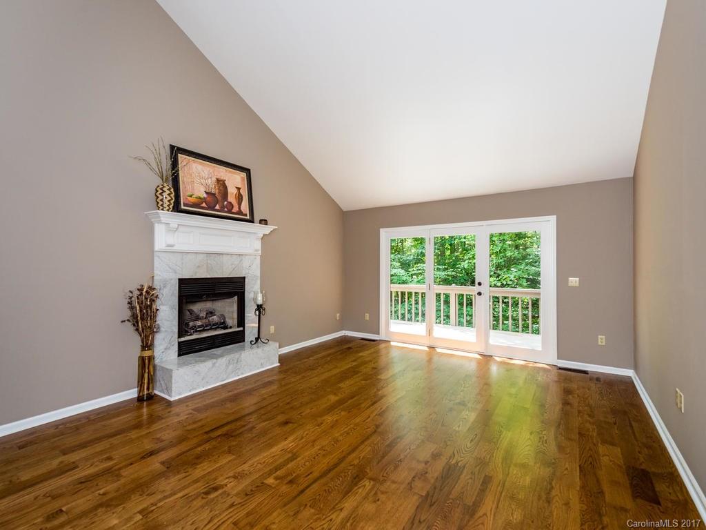 107 Old Distillery Road Hendersonville, NC 28739 - Photo 2 of 24 a view of empty room with wooden floor and fireplace