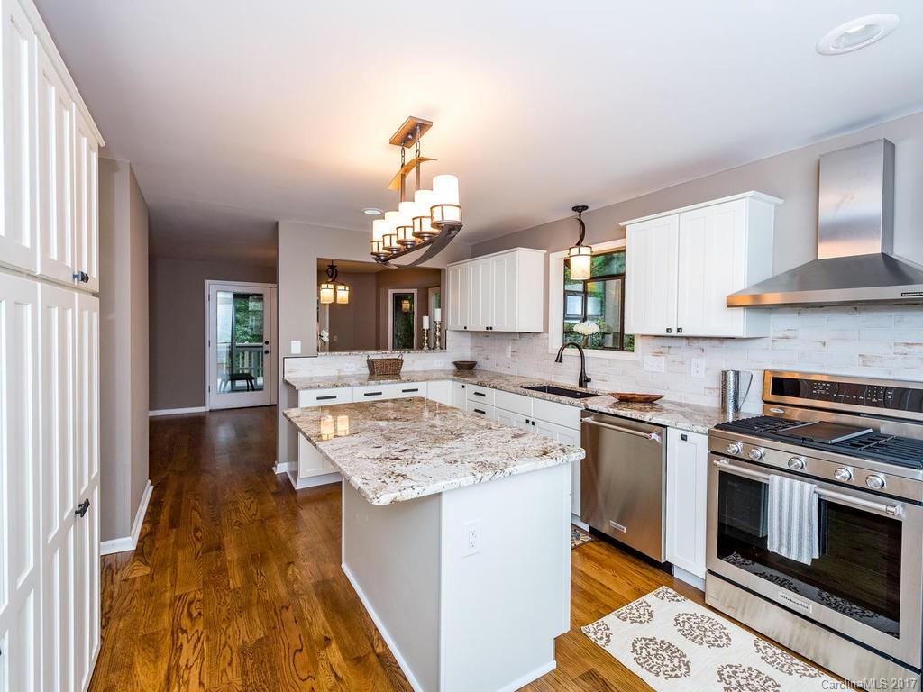 107 Old Distillery Road Hendersonville, NC 28739 - Photo 6 of 24 a kitchen with kitchen island granite countertop a sink cabinets and stainless steel appliances