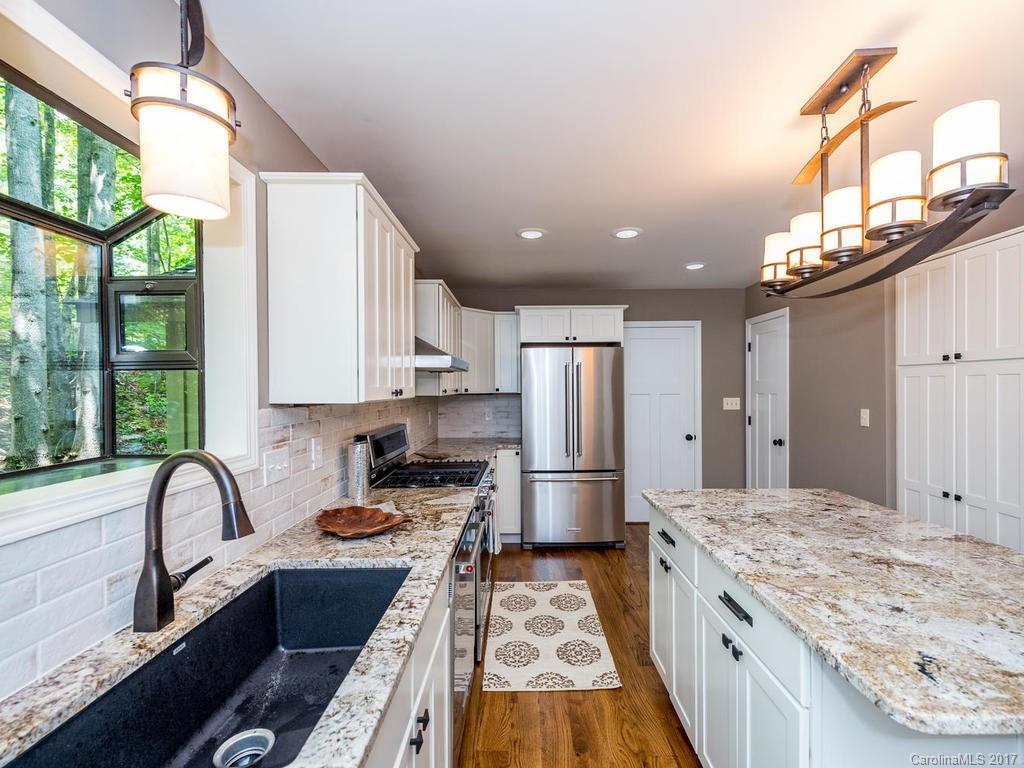 107 Old Distillery Road Hendersonville, NC 28739 - Photo 7 of 24 a kitchen with refrigerator a stove a sink dishwasher and cabinets with wooden floor