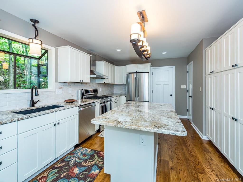 107 Old Distillery Road Hendersonville, NC 28739 - Photo 8 of 24 a kitchen with stainless steel appliances granite countertop a sink window and cabinets