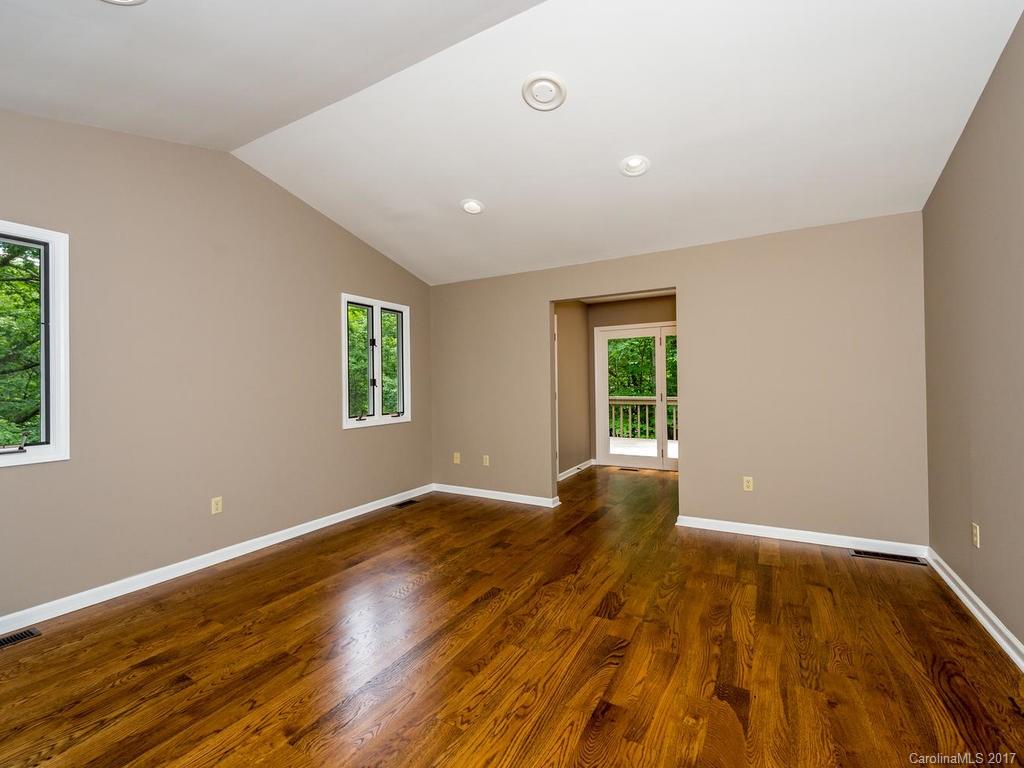 107 Old Distillery Road Hendersonville, NC 28739 - Photo 9 of 24 a view of an empty room with wooden floor and a window