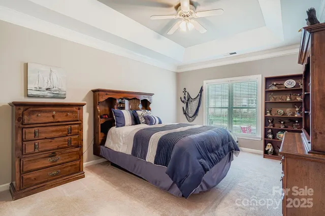 a bedroom with a bed a large window and book shelf