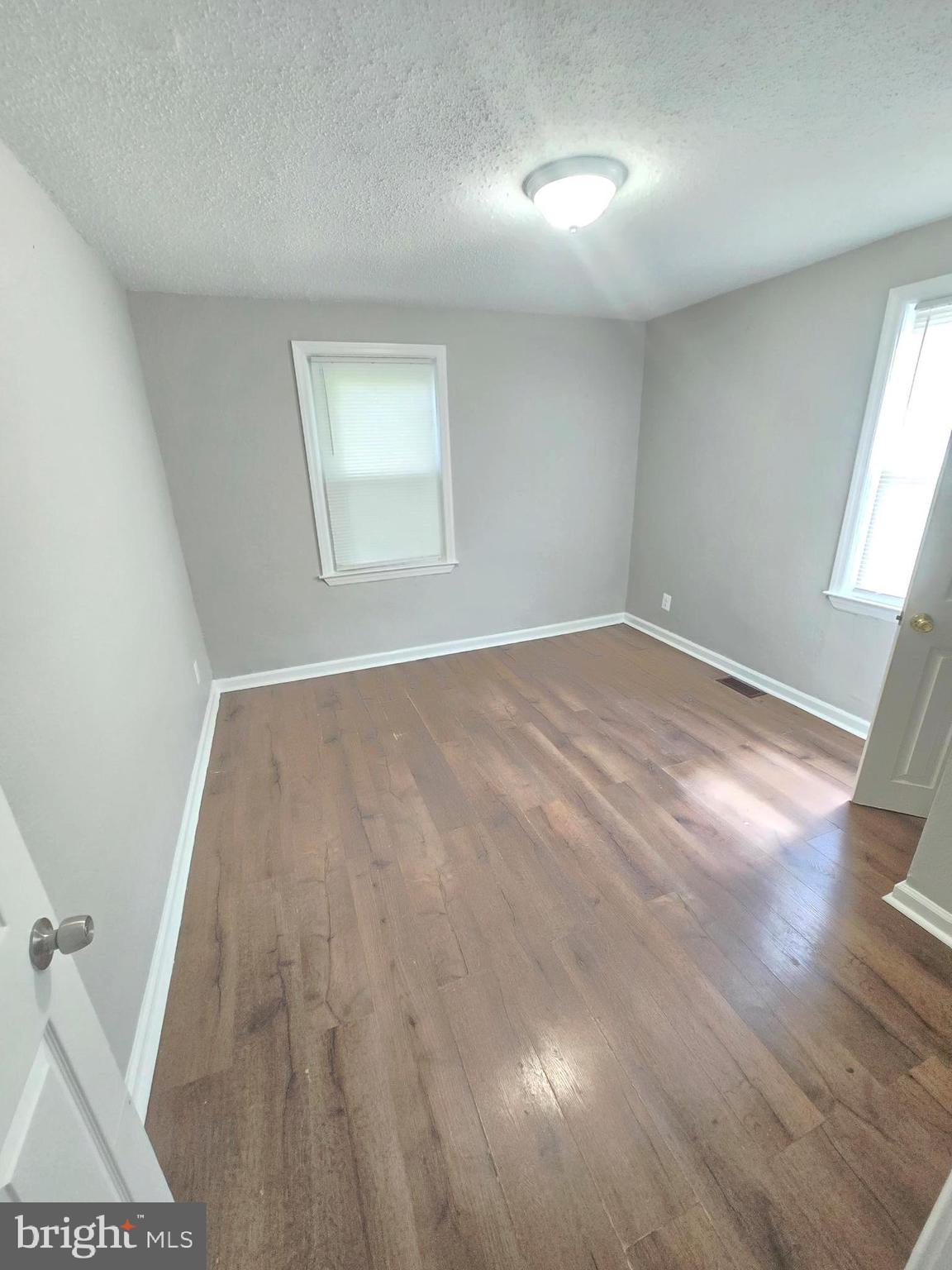 5413 Belle Vista Avenue Baltimore, MD 21206 - Photo 12 of 14 wooden floor in an empty room with a window