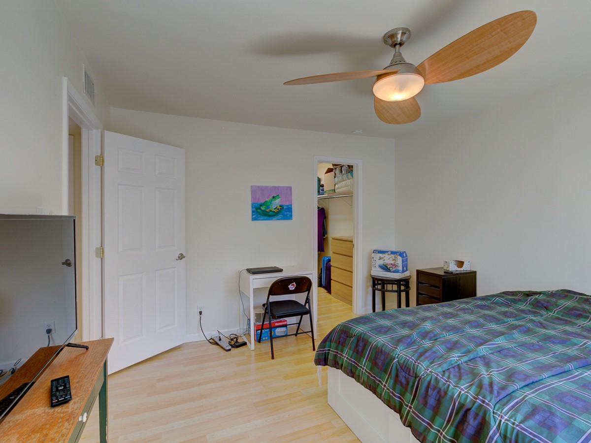 710 Castle Ridge Road, Unit B Austin, TX 78746 - Photo 18 of 27 A well-lit bedroom features hardwood flooring and a convenient walk-in closet.