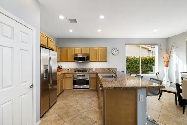 a view of a patio with couches and table and chairs and potted plants
