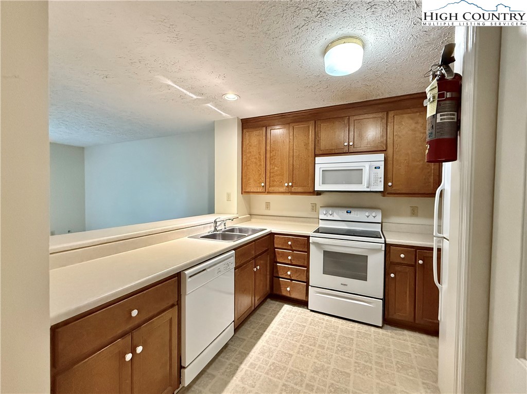 800 Meadowview Drive, Unit 17 Boone, NC 28607 - Photo 12 of 26 a kitchen with a stove sink and cabinets