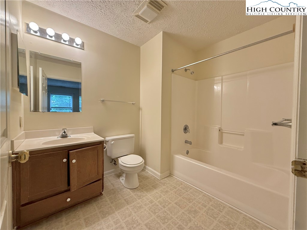 800 Meadowview Drive, Unit 17 Boone, NC 28607 - Photo 19 of 26 a bathroom with a granite countertop sink toilet and shower