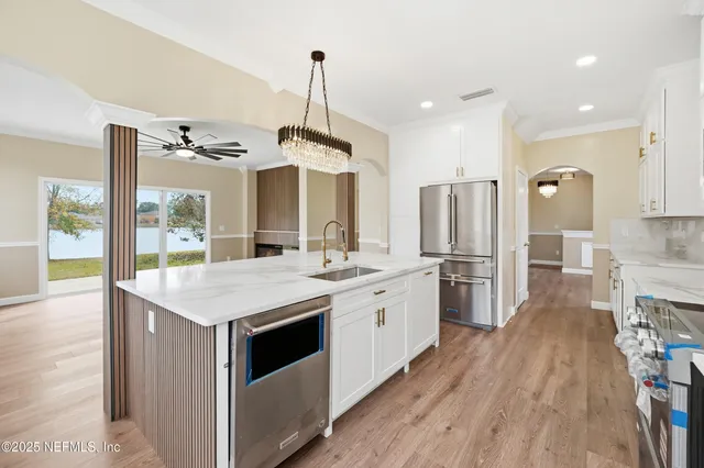 a kitchen with stainless steel appliances a lot of counter space and wooden floors