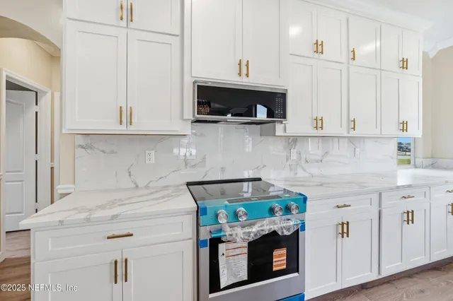 a kitchen with stainless steel appliances granite countertop a stove a microwave and cabinets