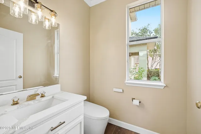 a bathroom with a granite countertop sink mirror and toilet