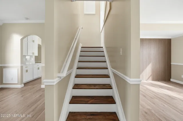 a view of staircase with wooden floor and white walls