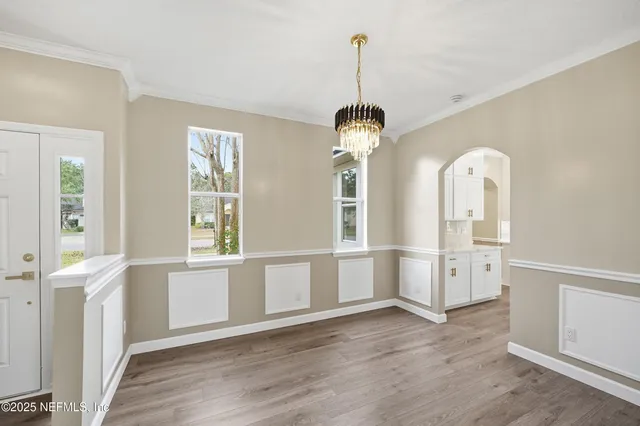 a view of a big room with wooden floor windows and chandelier
