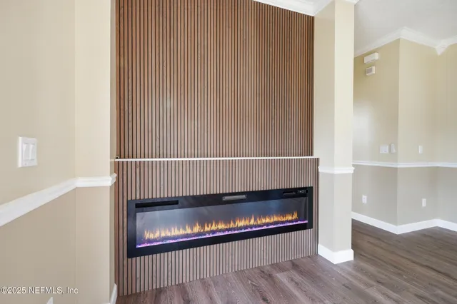 a living room with a fireplace and wooden floor