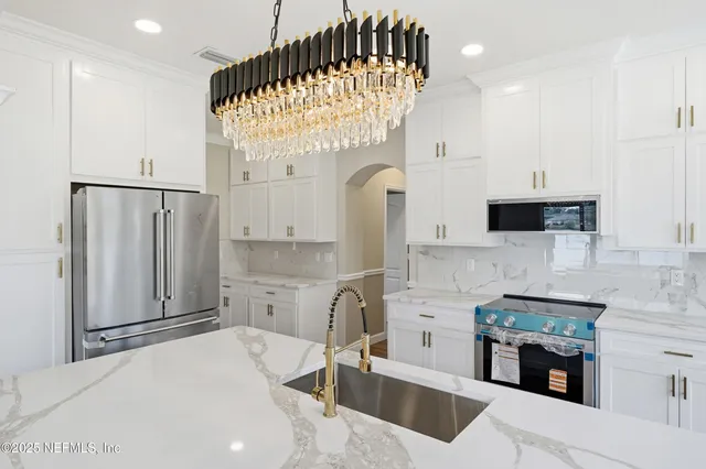 a kitchen with stainless steel appliances kitchen island granite countertop a sink and cabinets