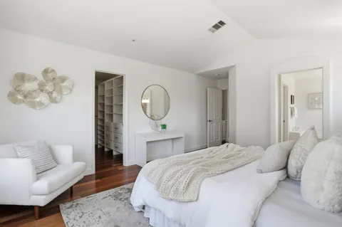 a bedroom with a bed couch and a mirror
