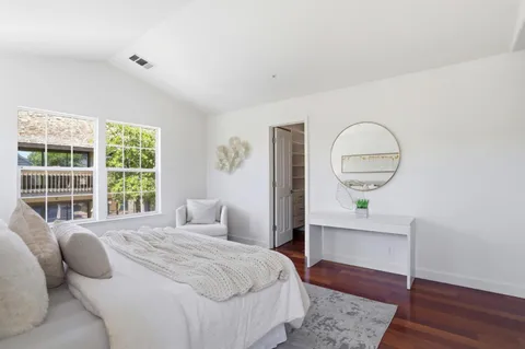 a bedroom with a bed windows and a table