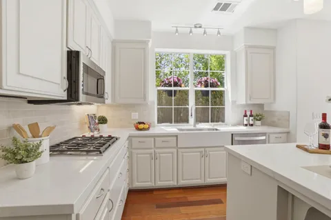 a kitchen with stainless steel appliances granite countertop a sink stove and cabinets