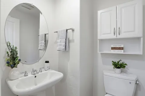 a bathroom with a sink a toilet and a mirror