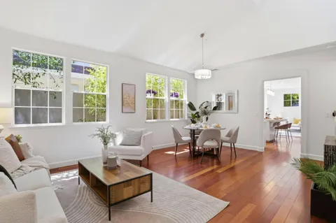 a living room with furniture dining table and a large window