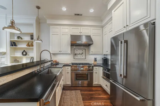 a kitchen with a refrigerator a sink and a stove top oven
