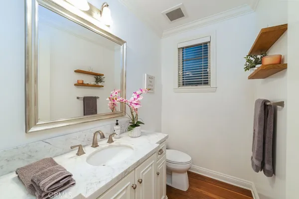 a kitchen with a sink and wooden floor