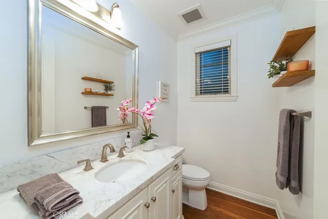 a kitchen with a sink and wooden floor