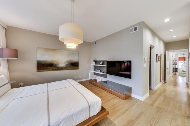 357 West Superior Street, Unit AB Chicago, IL 60654 - Photo 18 of 50 a bedroom with a bed and a flat screen tv