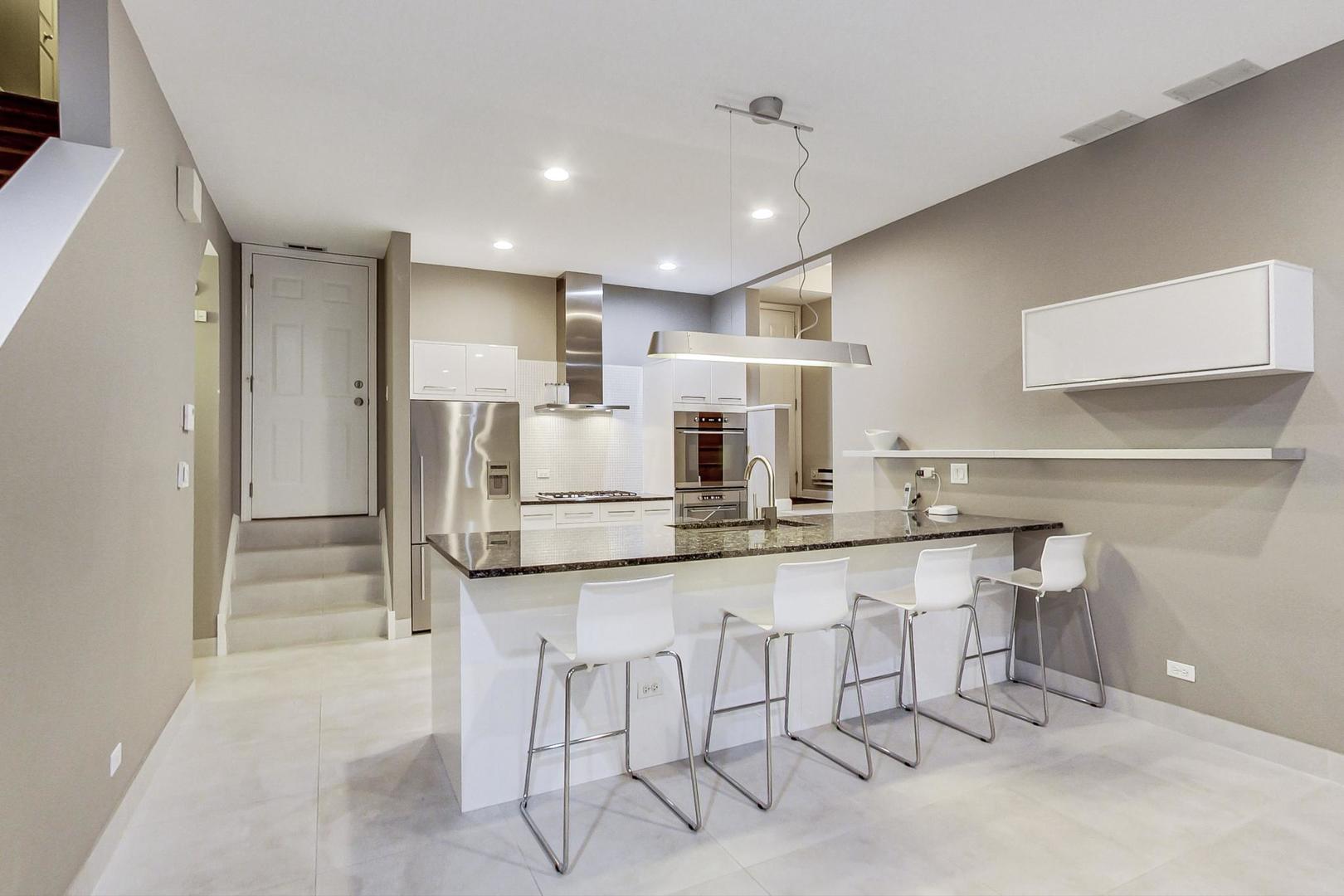 357 West Superior Street, Unit AB Chicago, IL 60654 - Photo 40 of 50 a kitchen with white cabinets and chairs