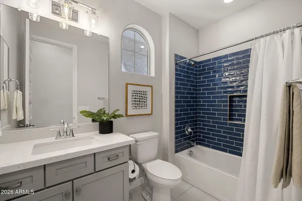 a bathroom with a sink a toilet a mirror and shower