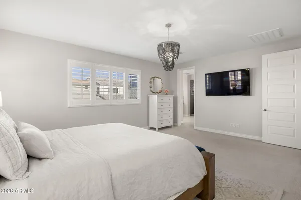 a spacious bedroom with a bed and a flat screen tv