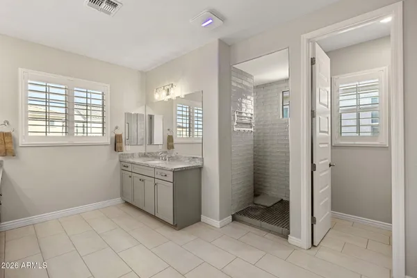 a bathroom with a granite countertop sink and shower