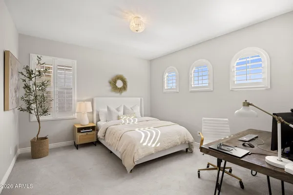 a bedroom with a bed and a potted plant