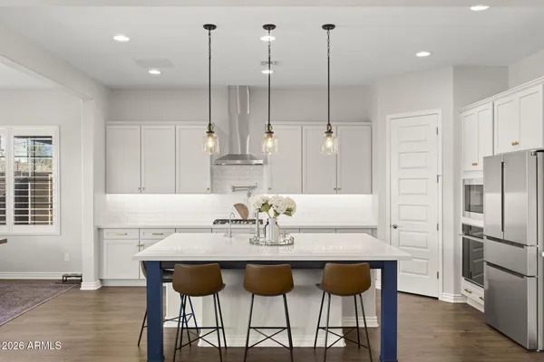 a kitchen with a dining table chairs and refrigerator