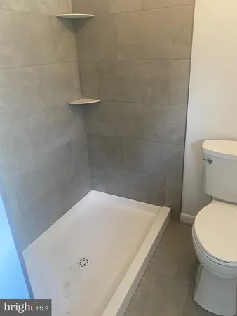 a bathroom with a toilet and a shower