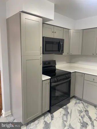 a kitchen with a refrigerator and a stove top oven