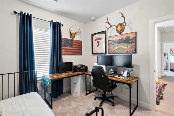 a view of a workspace with furniture and a window