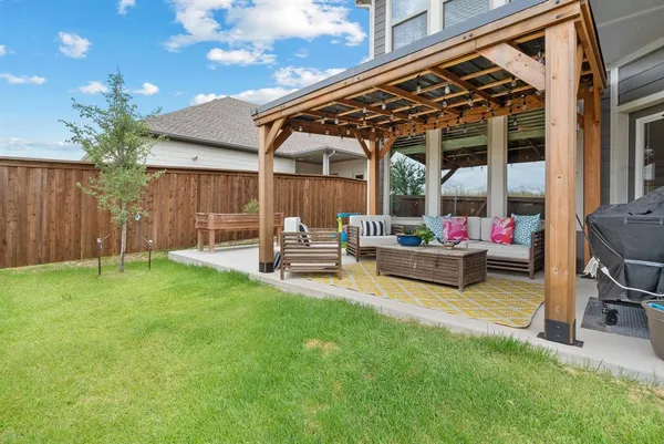 a view of a patio with table and chairs and potted plants with wooden fence